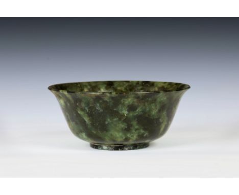 A Chinese carved spinach jade bowl, 20th century, typical form with everted rim and shallow circular foot, in mottled spinach