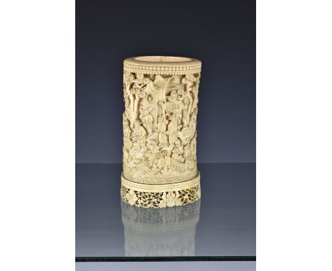 A 19th century Chinese Canton carved ivory brush pot, the slightly carved cylindrical pot deeply carved with an extensive gar