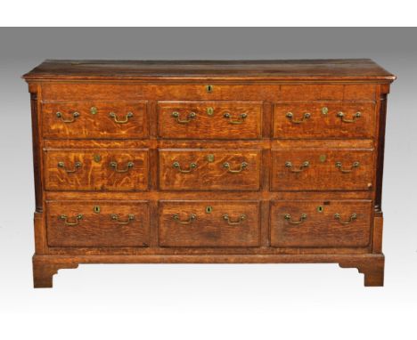 A George III cross banded oak mule chest, the moulded and mahogany cross banded three quarter-hinged top with shallow compart
