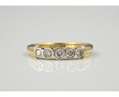 A 9ct yellow gold and diamond five stone ring, with five brilliant cut diamonds in a rub over setting, total 0.25ct, ring siz