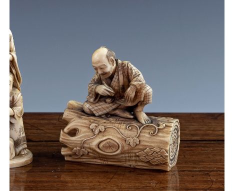 A Japanese carved ivory okimono, Meiji period (1868-1912), in tea stained ivory, depicting an elderly man with a pipe seated 