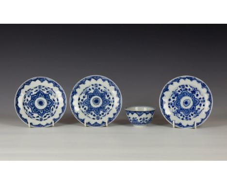 A set of three Chinese porcelain blue and white saucers, probably Kangxi period, painted with a central flowerhead within an 