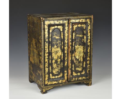 A Chinese export black lacquer table cabinet, early 19th century, with twin panelled doors and shaped bracket feet, decorated