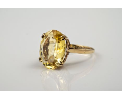 A 9ct yellow gold and citrine single stone ring, hallmarked Birmingham 1970, the pale, oval cut citrine claw set over an open