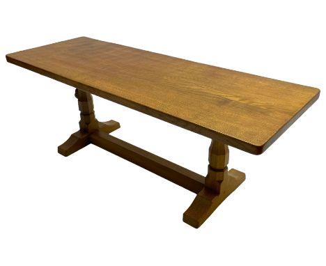 Mouseman - oak coffee table, rectangular adzed top on twin octagonal pillar supports, sledge feet united by floor stretcher, 