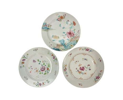 Three 18th century Chinese Famille Rose plates, the first example enamelled with blossoming peonies, rockwork and fence, the 