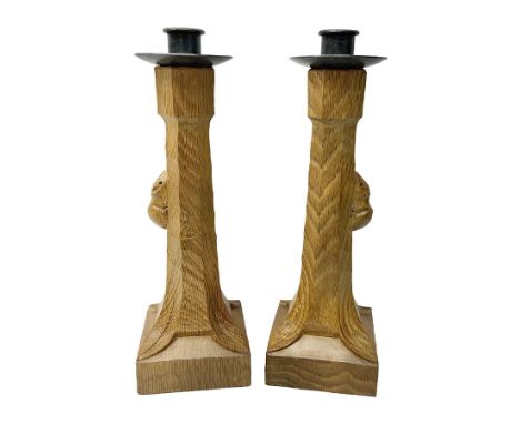 Mouseman - pair of tooled oak candlesticks, wrought iron sconce with drip tray over tapered octagonal column carved with mous