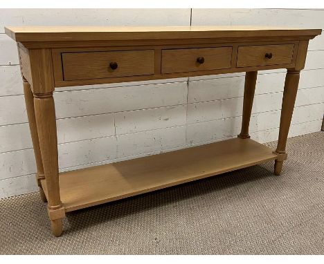 A light oak console table with three drawers on turned legs (H76cm W130cm D38cm)