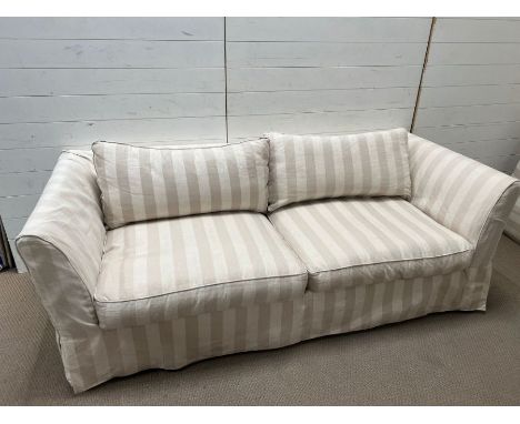 A large two seater sofa with striped loose covers (H72cm W207cm D90cm SH42cm)