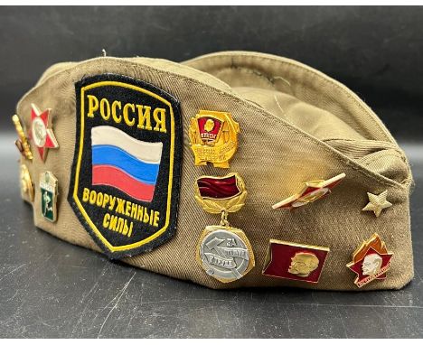 Russian army badges on a Russian military cap with assorted pin badges 