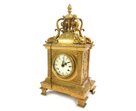 An Imperial brass cased mantel clock, circular enamel dial bearing Roman numerals, eight day movement with bell strike, the c