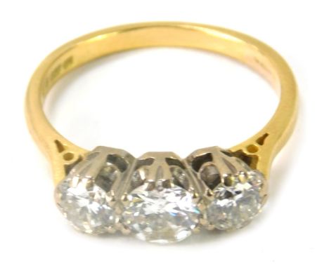 An 18ct gold and three stone diamond dress ring, with three round brilliant cut diamonds, the central stone, 5.4mm x 5.4mm x 