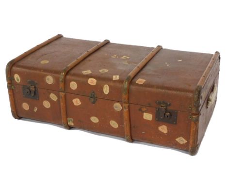 An early 20thC canvas and wooden bound travel trunk, with cast iron lock plates and leather carrying handles, 91cm wide, 51cm