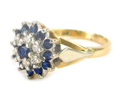 An 18ct gold sapphire and diamond cluster ring, the central stone sapphire surrounded by halo of diamonds and further surroun