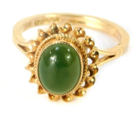 A 9ct gold jade dress ring, with cabachon cut jade in a rub over ribbon and rope edged setting, on a plain design band, size 