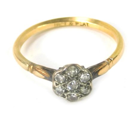 A Victorian diamond cluster ring, with seven illusion set tiny diamonds, in platinum ring head, on yellow metal band stamped 