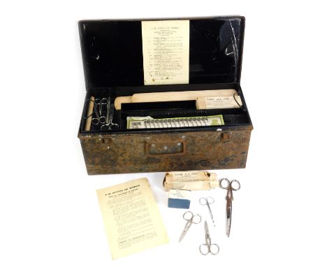 A vintage first aid kit, in black metal tin, enclosing supplies from the 50s and 60s. 