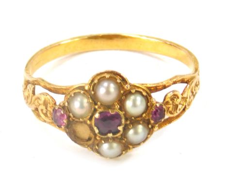 A Victorian memorial ring, the central design set with seed pearls and garnets, with twist design shoulders and open work bac