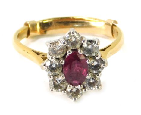 An 18ct gold ruby and diamond cluster ring, the oval ruby in an eight claw setting, surrounded by eight round brilliant cut d