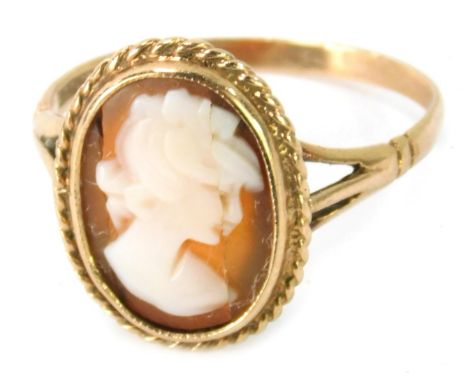 A 9ct gold cameo dress ring, the oval cameo depicting maiden looking right, with rope twist border, on V splayed shoulders, r