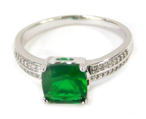 A dress ring, with central green paste stone, with CZ set shoulders, in a white metal setting, believed to be silver, but unm