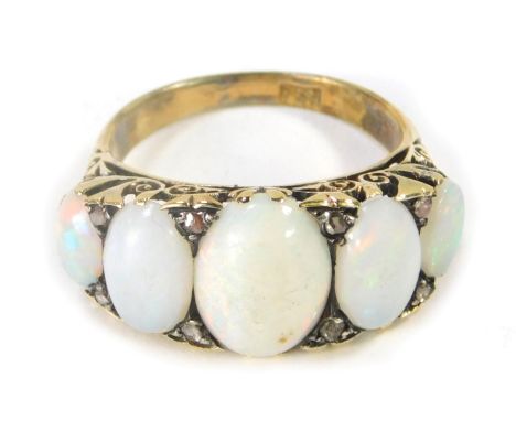 A Victorian opal and diamond dress ring, set with three oval opals, with eight tiny diamond set breaks, the central opal 11mm