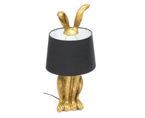 A hare table lamp, the gilt decorated hare with black shade, the top with two shaped ears, 80cm high.