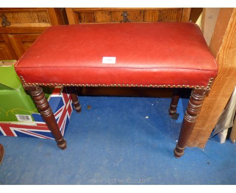 A red dressing table stool, faux red leather seat.