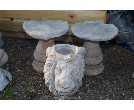 Concrete lion's head planter and two concrete shell type bird baths.