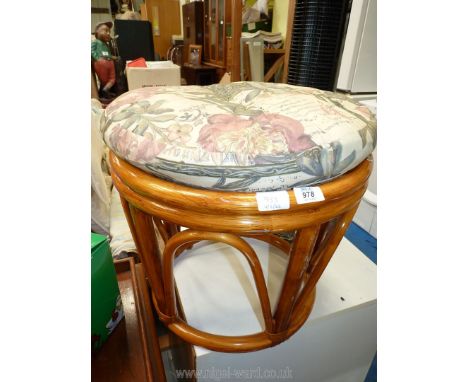 A bamboo stool with padded cushion.