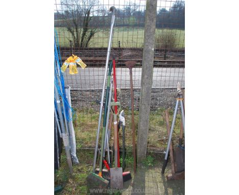 A quantity of garden tools to include; rake, lopper, etc.