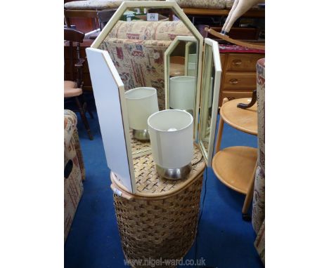 A wicker linen basket, lamp and mirror.