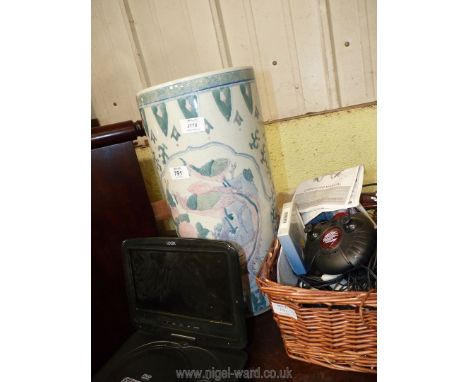 A ceramic stick stand and basket of controllers, video player, cables etc.