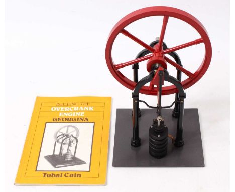 A "Georgina" overcrank stationary steam engine comprising a large flywheel, a single cylinder, with a steam pipe and exhaust 