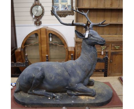 A large bronzed metal model of a recumbent stag H.88cm, W.100cm