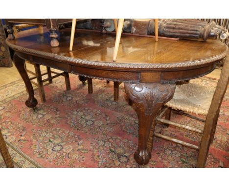 A Chippendale style oak extending dining table with one spare leaf W.190cm