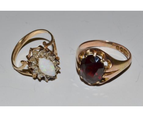 A 9ct gold ring set with a garnet, a 9ct gold ring set with opals and diamonds