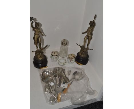 A pair of French spelter figures, Le Jour and La Nuit;  flatware;  a three piece porcelain cruet set with silver plated tops 