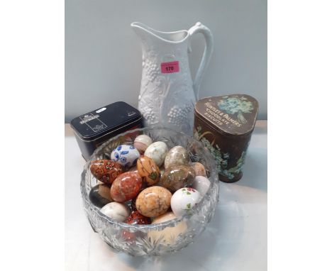A collection of decorative eggs in onyx, wood and china together with two vintage tins and a white Portmeirion parian style w