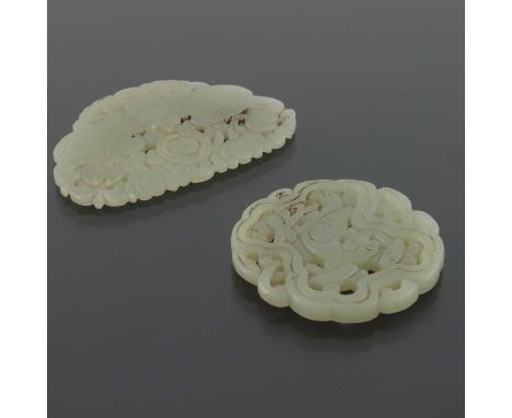 Two Chinese reticulated jade pendants, one carved with a moth, the other with a bird within foliate scroll border, 7cm wide (