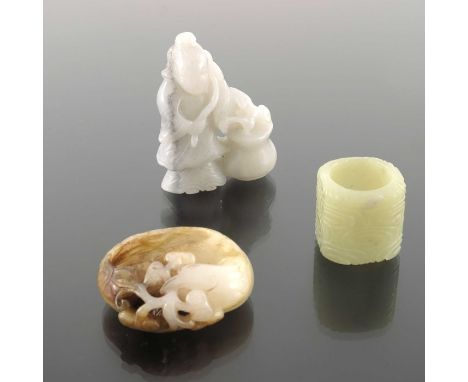 Three Chinese hardstone carvings, including a jade archers ring with archaistic scrolling clouds, a russet included ink pot m