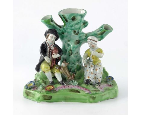 Early 19th Century Staffordshire pottery pearlware tree trunk figure group, seated man with pipes and dog with rested paws, h