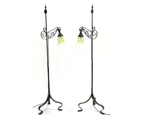 A pair of Arts and Crafts wrought adjustable standard lamps, Clements Newling and Co., the open scroll arms on tapered poles 