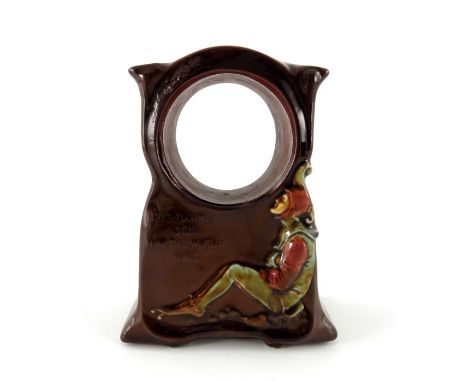 Charles Noke for Royal Doulton, a Kingsware Jester clock case, with verse, relief moulded of ogee pedestal bracket form, rais