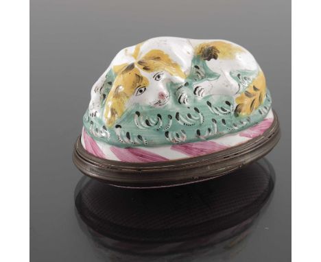 An 18th century Bilston enamel snuff box, modelled in relief with a resting dog on a cushion, the lid with stylised floral sp