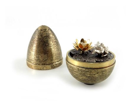 Stuart Devlin, a Modernist silver gilt surprise egg, London 1972, textured, opening to reveal a frog and lily pad, numbered 2