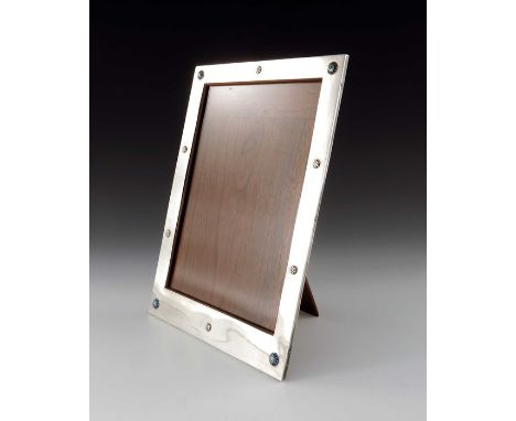Liberty and Co., an Arts and Crafts silver and enamelled photo frame, Birmingham 1919, rectangular form, studded with alterna