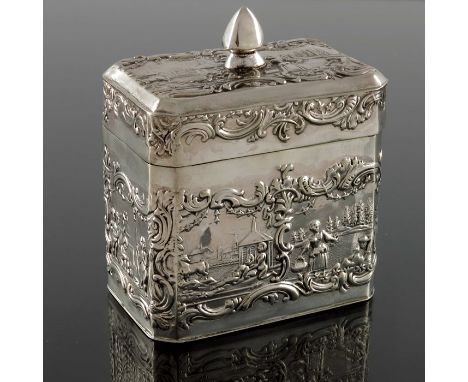 A Dutch silver tea caddy, cuboid form with hinged lid, embossed with rural scenes and putti, within foliate scroll and shell 