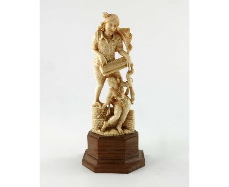 λ A 19th century Indian carved ivory figurine, modelled as a harmonium player with a female dancer, on wooden base, 14cm high