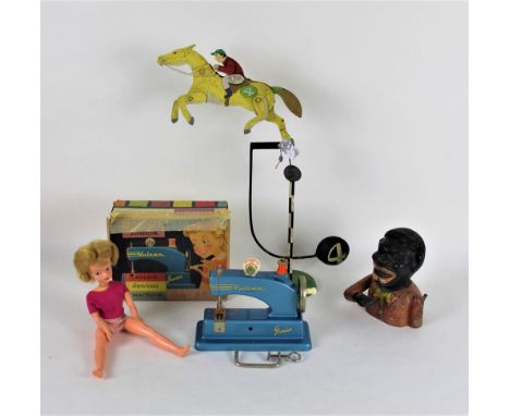 A vintage jockey and horse balancing toy, a Jolly man money bank, a Vulcan child's sewing machine, and a Pedigree Sindy doll 